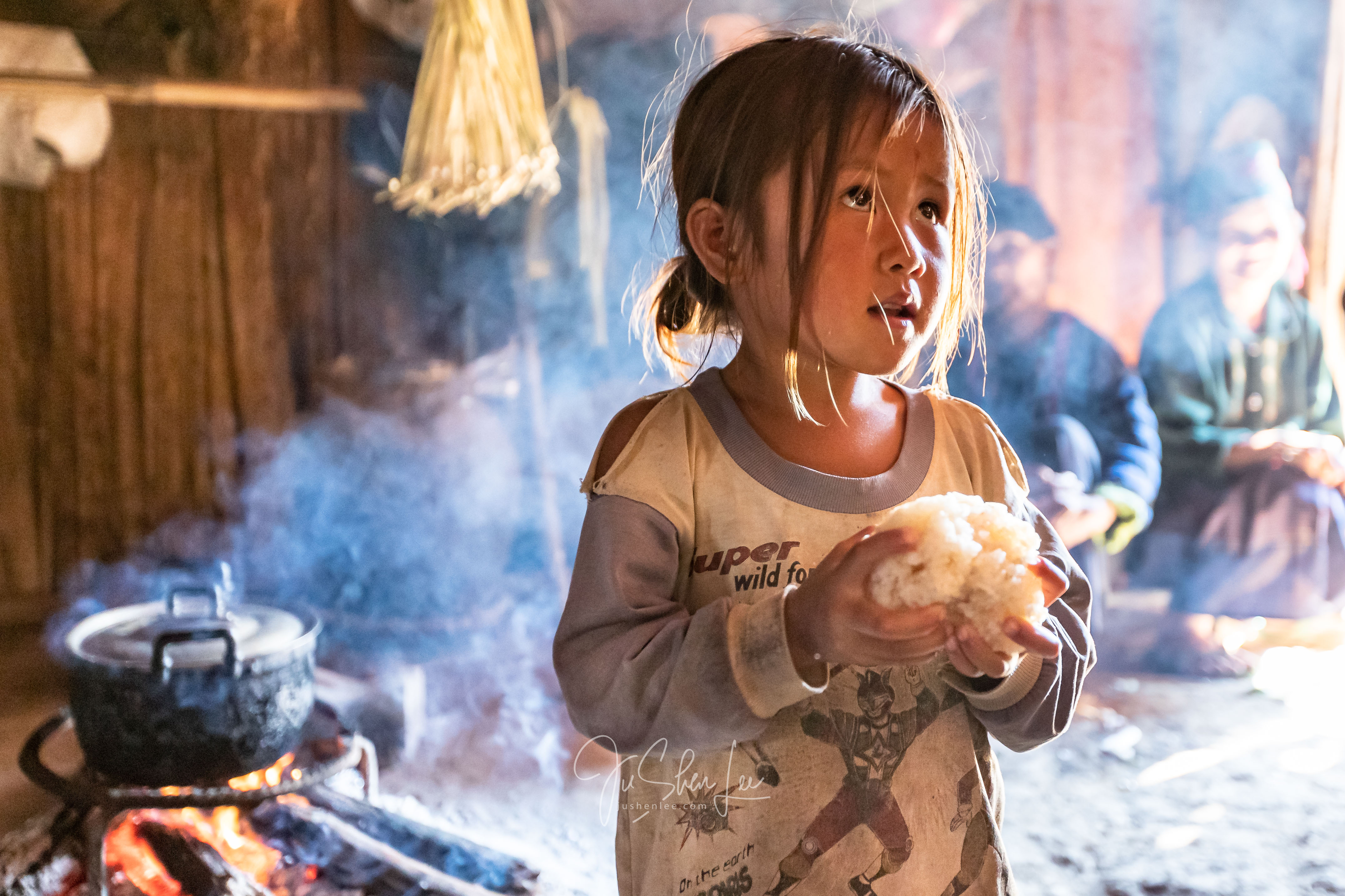 Child holding a ball of rice in Phoumieng, Laos
