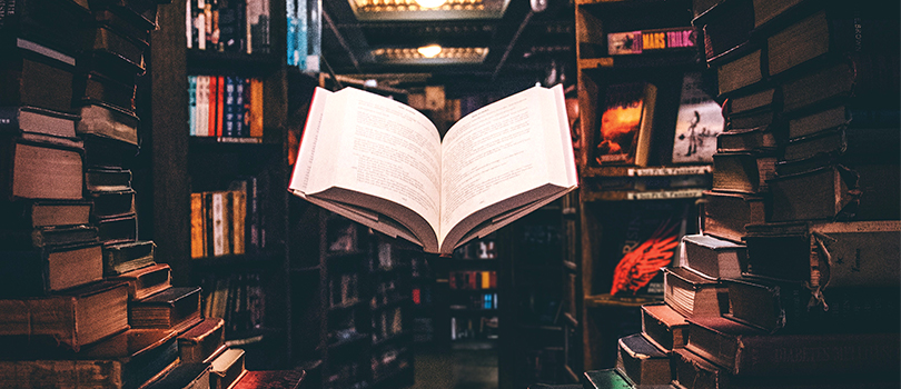 Livre ouvert qui flotte dans une bibliothèque