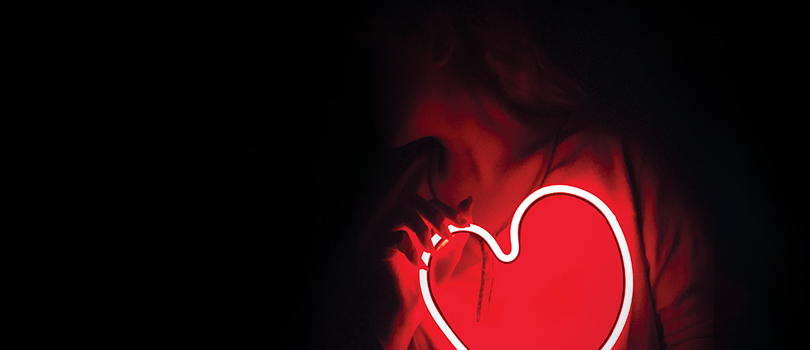 Woman holding fluorescent heart shape