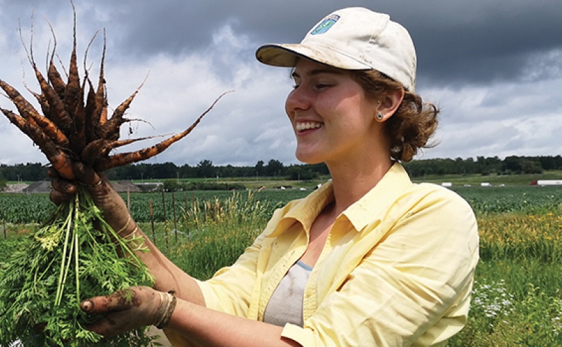 Kayla Dowd holding a bunch of carrots
