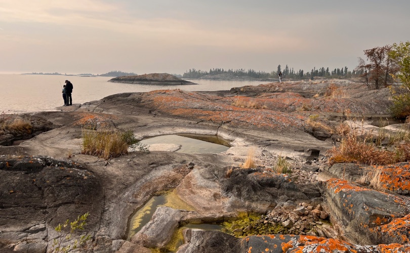 Two people standing at the edge of a body of water