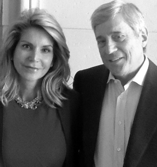 Two individuals standing in front of a wall