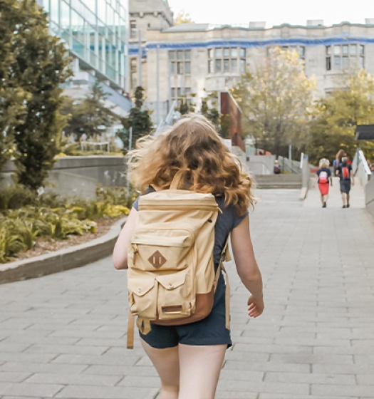 Person with backpack walking away from camera