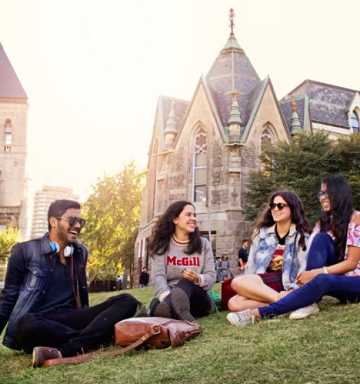 Four students sitting on the front lawn of McGill campus.