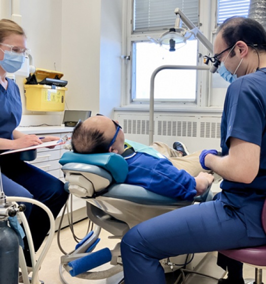 A group of people working around a patient on a dental chair