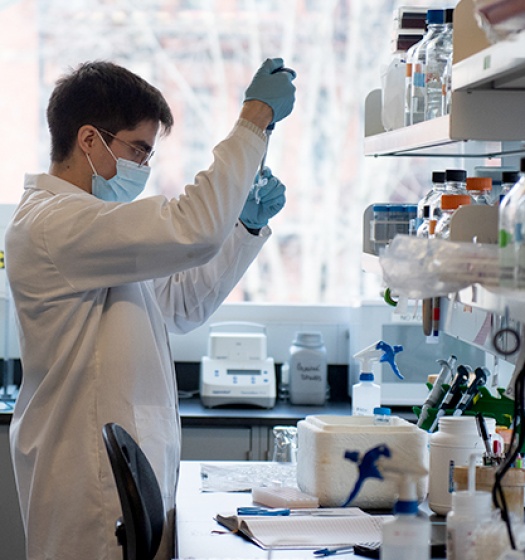 A man wearing a mask and gloves in a laboratory