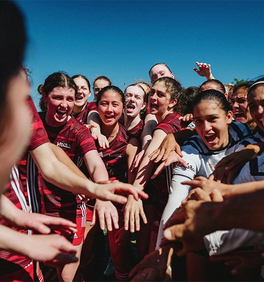 A group of players reaching their hands together.