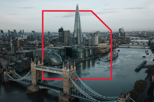 A bridge over a river with a tower and a city in the background